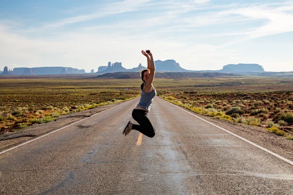 Hoppa flicka på väg nära Monument Valley — Stockfoto