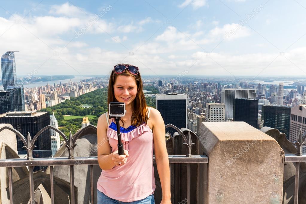 Girl taking selfie with view to Uptown Manhattan