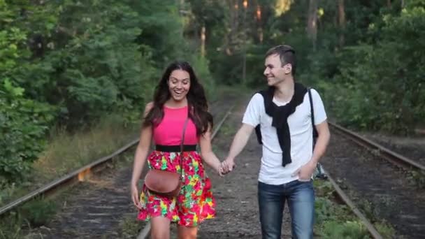 Ragazzo e ragazza che camminano sui binari nella foresta — Video Stock