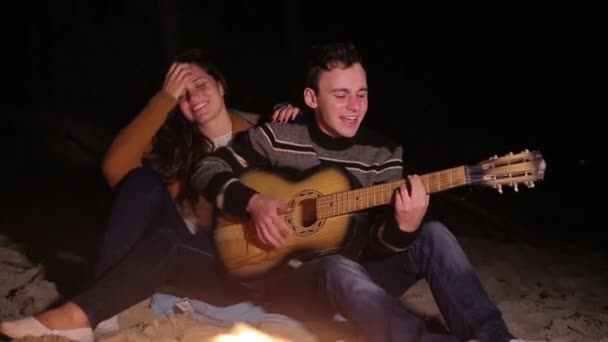 Man spelen quitar voor het meisje door het vuur — Stockvideo