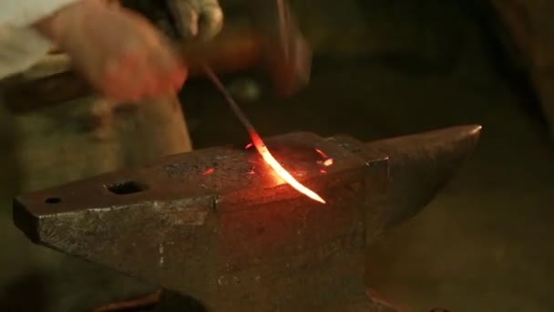 Martillos herrero en la pieza de hierro al rojo vivo — Vídeo de stock