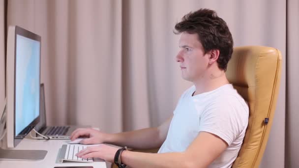 Людина брюнетка працює за комп'ютером вдома — стокове відео