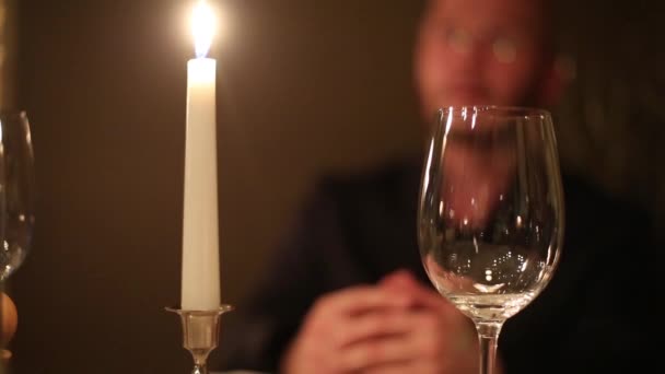 Verre et bougie ferment et l'homme sur le fond — Video