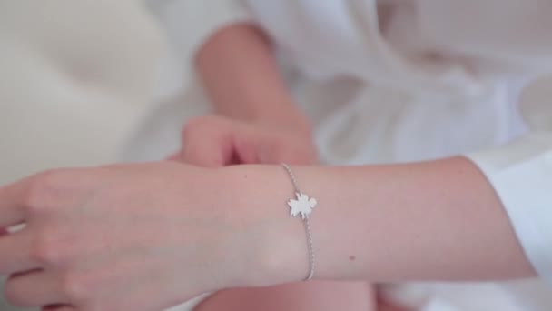 Menina corrige uma pulseira em seu braço — Vídeo de Stock