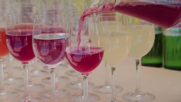 Cranberry juice is poured into glasses — Stock Video