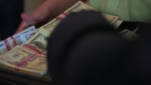 El hombre pone paquetes de dólares falsos en una bandeja — Vídeo de stock
