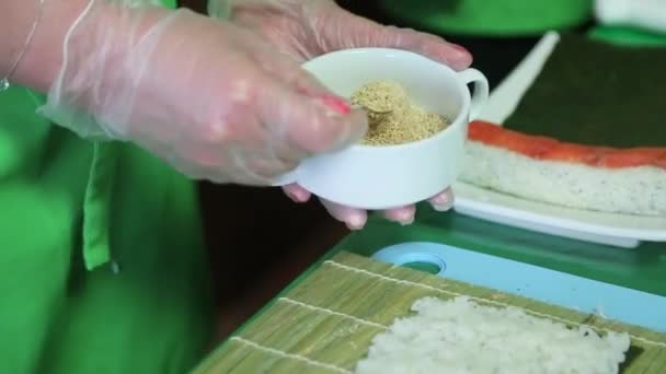 Sushi mestre sprinkles sésamo postado no arroz nori — Vídeo de Stock