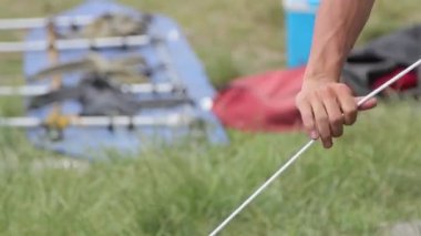 Kamp alanında bir ip çekerek adam