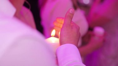 Bir mum tutan bir Beyaz tişörtlü adam