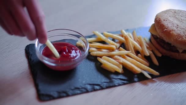 O tipo põe batatas fritas no ketchup — Vídeo de Stock