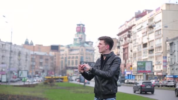 Tall guy makes photo of the city on smartphone — Stock Video