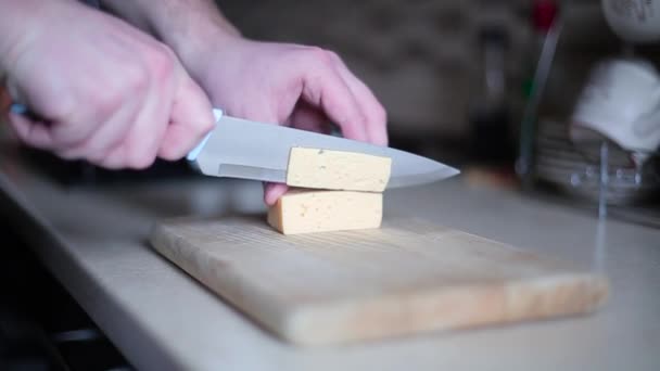 L'uomo taglia il formaggio a bordo da vicino — Video Stock