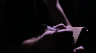 Adam karanlık bir defterde yazılı önlük