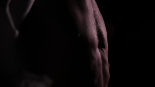 Torso muscular masculino en la oscuridad — Vídeo de stock