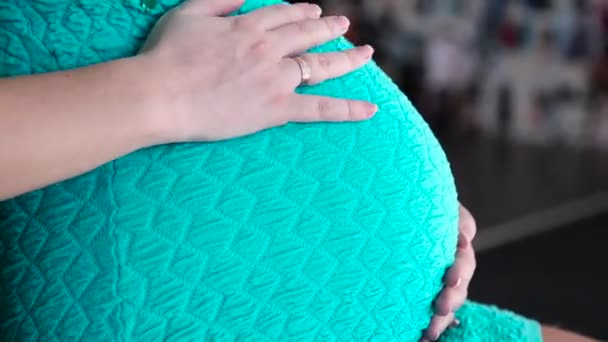 Беременная женщина в платье разжигает живот — стоковое видео