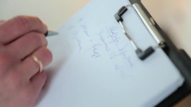 Bir adam bir alyans ile bir kağıt üzerine verileri kaydeder