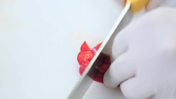 Шеф в перчатках режет помидор. — стоковое видео