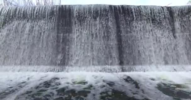 Ein kleiner Wasserfall und ein starker Fluss — Stockvideo