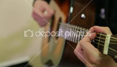 Adam akustik gitar çalıyor.