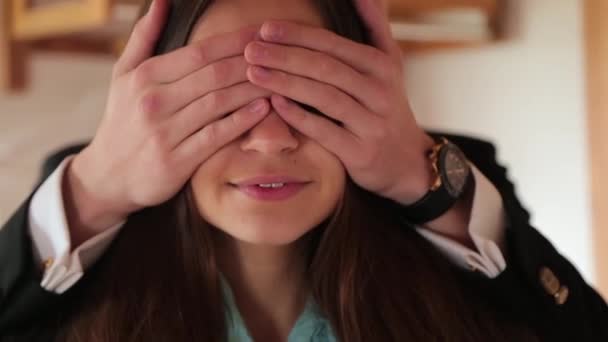 Homem fecha olhos de meninas com as mãos para surpresa — Vídeo de Stock
