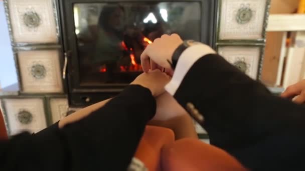 A couple holding hands and kissing near the fireplace — Stock Video