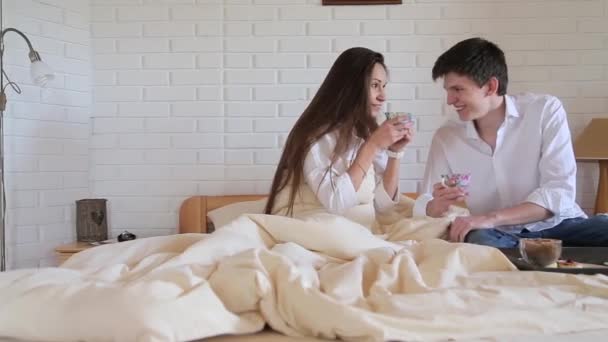 Пара п'є чай в ліжку в кімнаті лофт — стокове відео