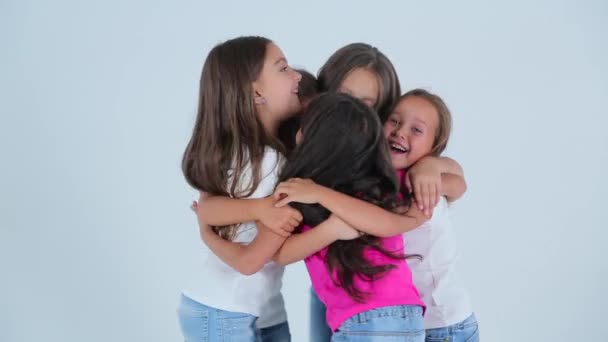 Маленькие девочки обнимаются и смеются на белом фоне — стоковое видео