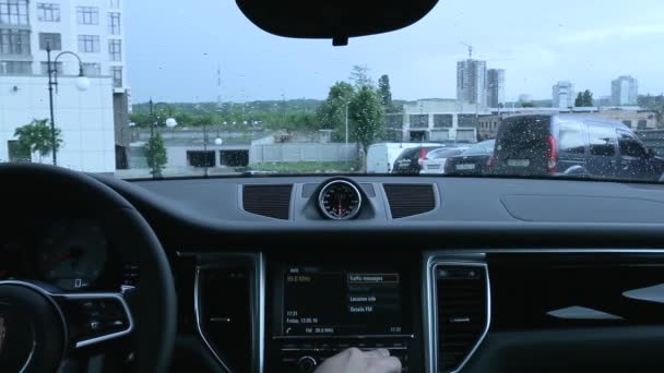 Człowiek wykorzystuje wyświetlacz w samochodzie w deszczowa pogoda — Wideo stockowe