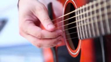 Adam kırmızı akustik gitar çalmak