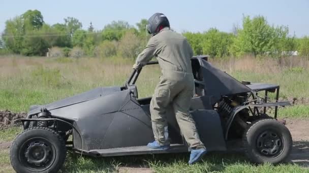 Homem de capacete senta-se no buggy — Vídeo de Stock