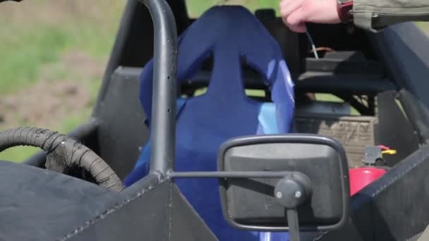 Homem de capacete senta-se no buggy — Vídeo de Stock