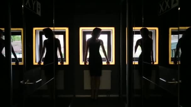 Silhoutte d'une fille sur un fond de fenêtre et de miroirs — Video