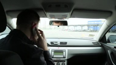 Araba arka görünümünde telefonda konuşan adam