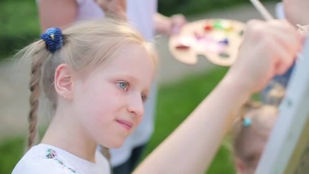 Niña dibuja pinturas con la familia — Vídeo de stock