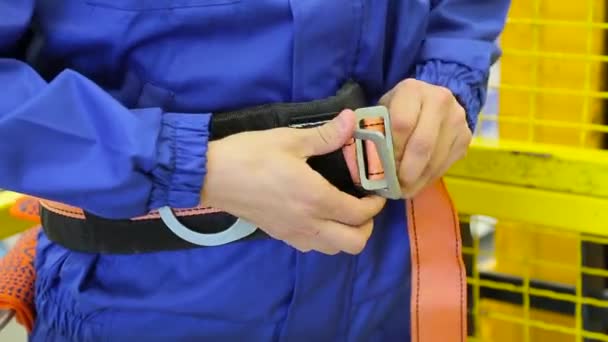 Hombre sujeta un cinturón de seguridad en el almacén — Vídeo de stock