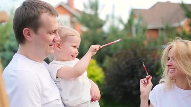 Föräldrarna spelar med dotter med färger — Stockvideo