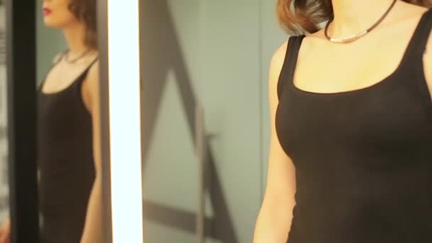 Girl in black evening dress going near mirrors — Stock Video