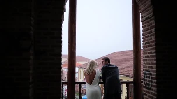 Pareja alojada en el balkony con vista al casco antiguo — Vídeo de stock