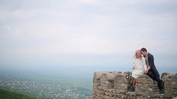 Couple sitting on the edge on the background of valley — Stock Video