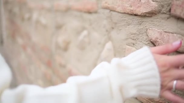 Chica caminando y acariciando una pared de ladrillo — Vídeo de stock