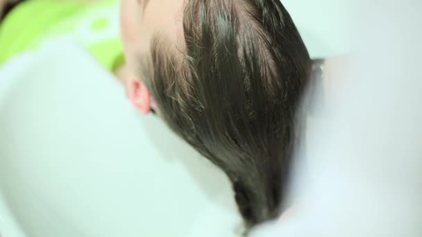 Девушка моет волосы у парикмахера — стоковое видео