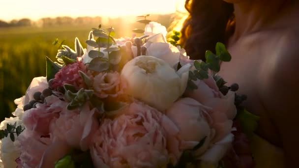 Дівчина з букетом квітів у полі — стокове відео