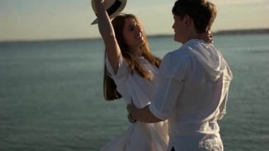 Kaç sarılma ve kız şapka deniz arka plan üzerinde oynamak