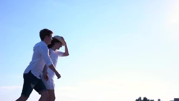 Pareja en ropa blanca corriendo sobre el fondo del cielo — Vídeo de stock