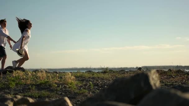 プロムナードの岩に沿って実行しているカップル — ストック動画