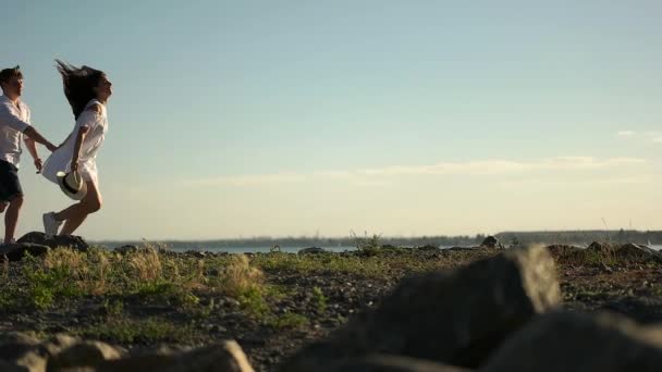 Par går längs klipporna på strandpromenaden — Stockvideo