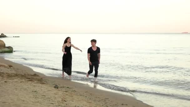 Couple courant pieds nus sur la plage — Video