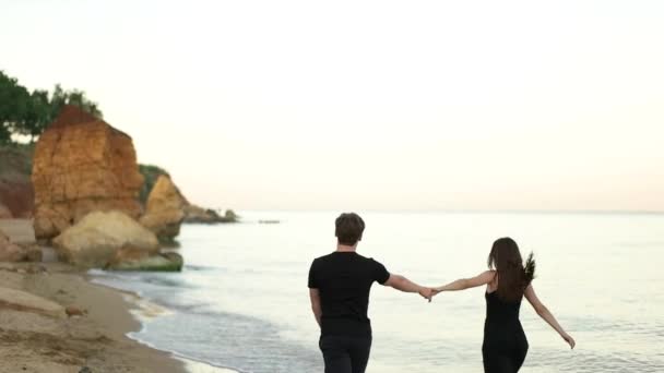Par kör håller hand barfota på stranden — Stockvideo