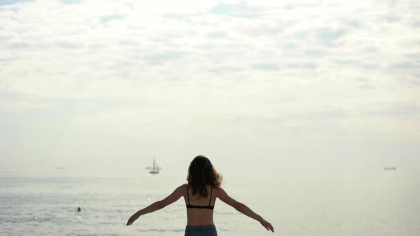 Дівчина піднімає руки на морі — стокове відео