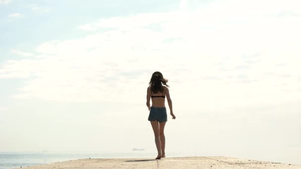 Flickan hoppar på piren vid havet — Stockvideo